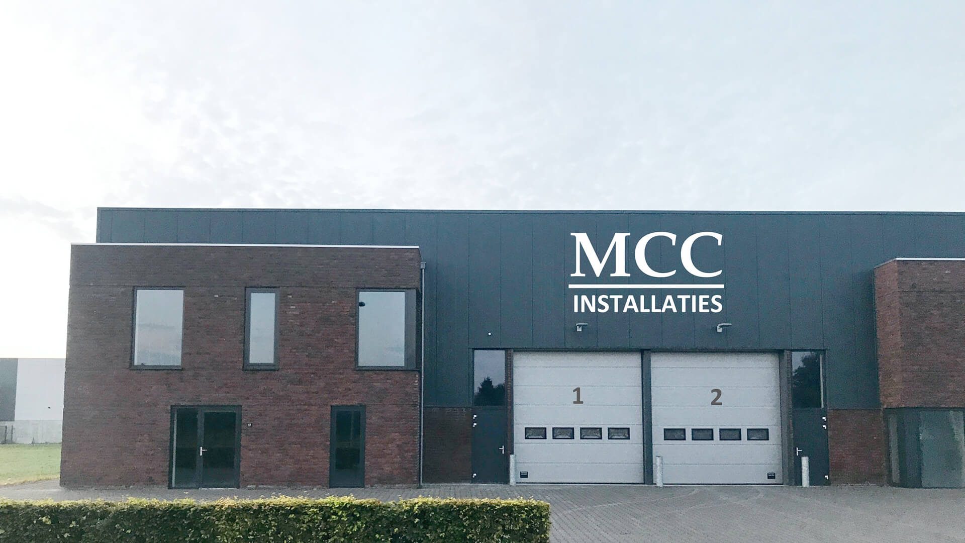 bedrijfspand MCC met logo uitgezoomd over ons ventilatie en WTW Prefab installaties Complete huisinstallaties